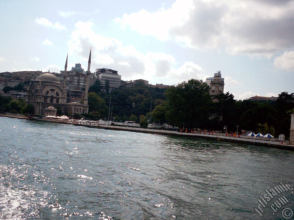 View of Dolmabahce coast, Valide Sultan Mosque and clock tower from the Bosphorus in Istanbul city of Turkey.

