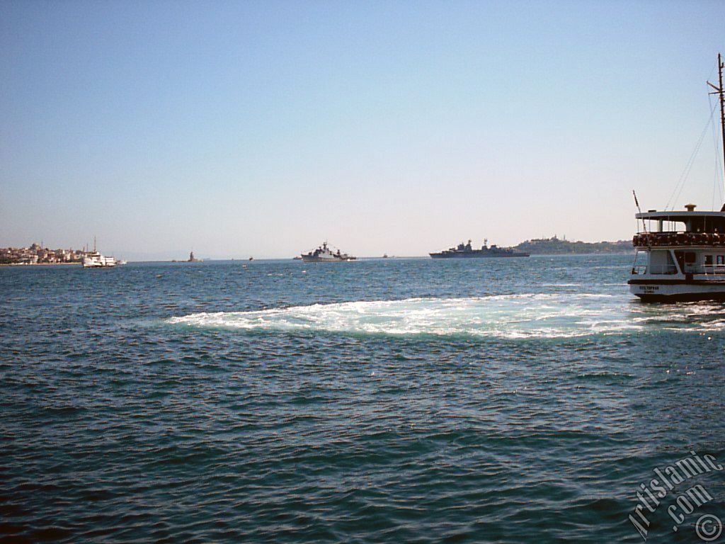 View of a landing ship, on the horizon Kiz Kulesi (Maiden`s Tower), Uskudar coast on the left and Sarayburnu coast on the rigth from the shore of Besiktas in Istanbul city of Turkey.
