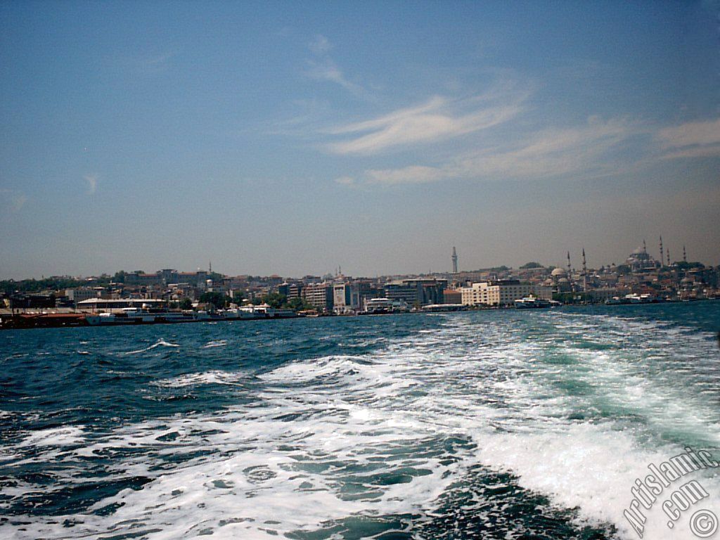 View of Eminonu coast, Beyazit Tower, Yeni Cami (Mosque) and Suleymaniye Mosque from the sea in Istanbul city of Turkey.
