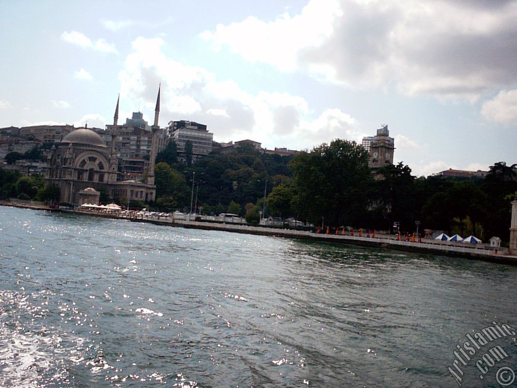 View of Dolmabahce coast, Valide Sultan Mosque and clock tower from the Bosphorus in Istanbul city of Turkey.
