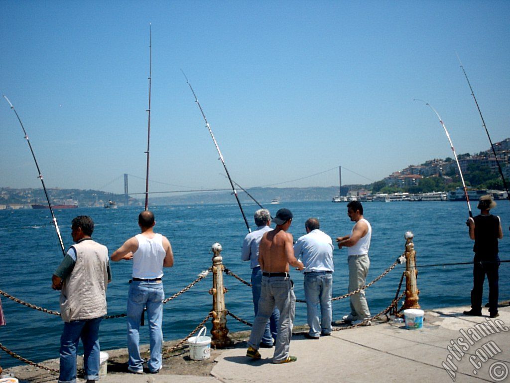 View of fishing people and on the horizon Bosphorus Bridge from Uskudar shore of Istanbul city of Turkey.
