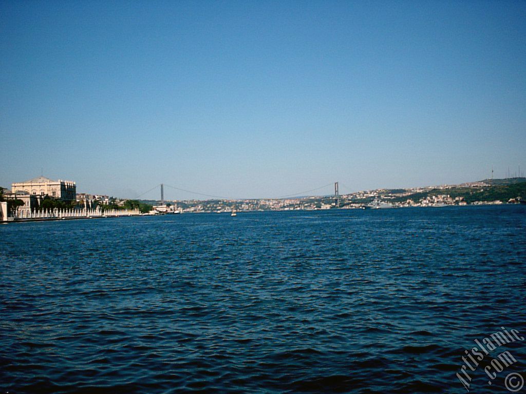 View of the Dolmabahce Palace, Bosphorus Bridge and Uskudar coast from a park at Dolmabahce shore in Istanbul city of Turkey.
