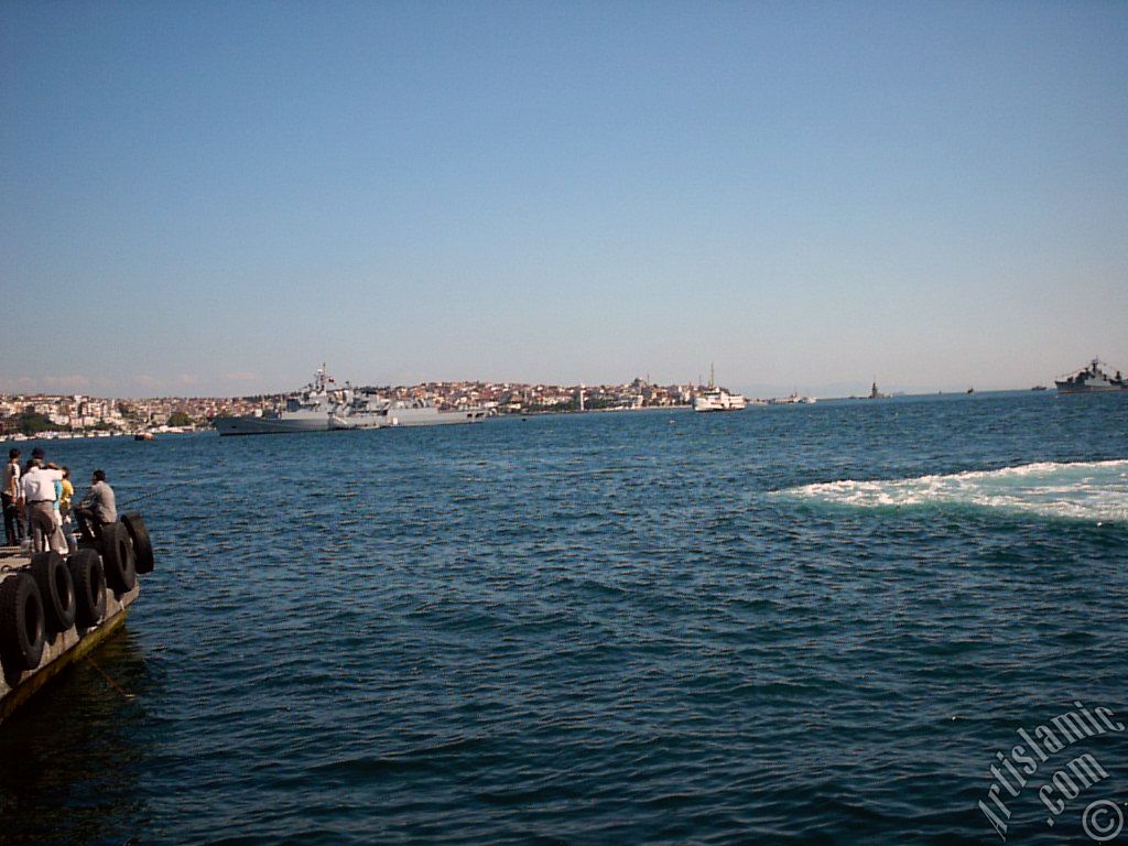 View of froth on the sea seen after a ship landed, on the horizon Kiz Kulesi (Maiden`s Tower), Uskudar coast on the left and fishing people from the shore of Besiktas in Istanbul city of Turkey.
