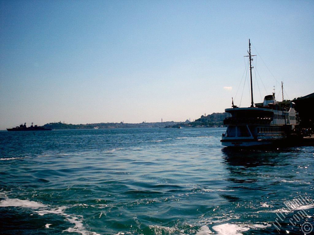 View of a landed ship at jetty and on the horizon Sarayburnu-Eminonu coast from the shore of Besiktas in Istanbul city of Turkey.
